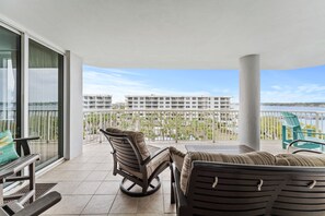 Enjoy the serene views of the water from this spacious balcony with two seating areas.