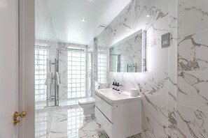 A modern bathroom with a marble floor, a white sink, and a large mirror. - Stylish apartment with terrace in Mayfair (London)