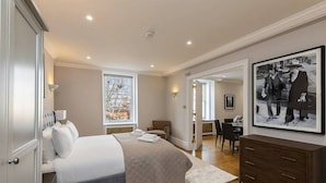Ein Schlafzimmer mit Bett, Kommode, Stuhl und Schreibtisch.