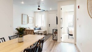 A modern living room with a dining area, a sofa, a coffee table, and a TV. - Desert Memories #76 by RedAwning (St. George)