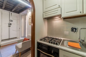 A kitchen with a gas stove, white cabinets, and a sink.