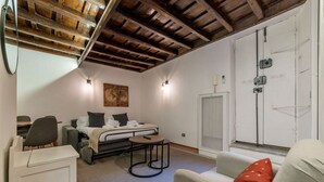 Une chambre à coucher de taille réduite, comprenant un lit, une petite table, une chaise et un canapé.