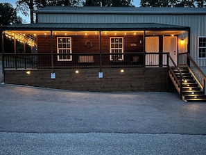 A wooden building with a porch, a staircase, and a 'Welcome' sign.