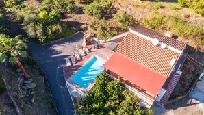 An aerial view of a property with a swimming pool, a covered patio, and a red-roofed building. - Villa Tropicana by Solset (Nerja)