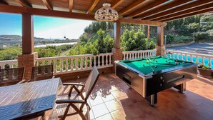 A pool table in a covered outdoor area with a view of a landscape. - Villa Tropicana by Solset (Nerja)