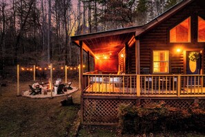 A wooden cabin with a porch, outdoor seating, and a fire pit. - ☆Renovated Cabin☆ Hot Tub ◇ Fire Pit ◇ Fireplace ◇ Dog-friendly (Sevierville)