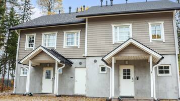 Stunning facade with a central entrance and two covered porches, each with a single column and small window.