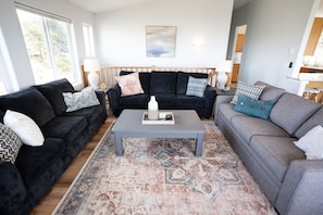 Ein Wohnzimmer mit zwei Sofas, einem Couchtisch und einem gemusterten Teppich.