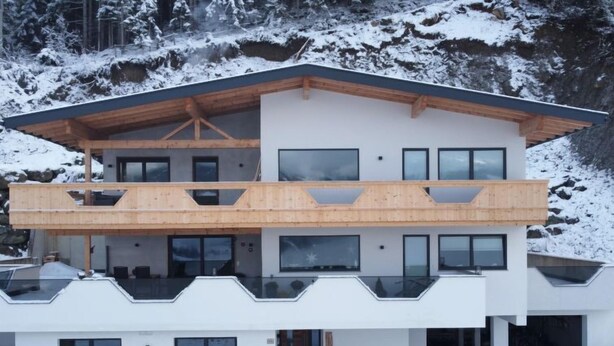 A modern two-story house with a wooden balcony and large windows. - Apartment Nina by Interhome (Hippach)