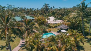 Un resort con piscina, palme e un gazebo.