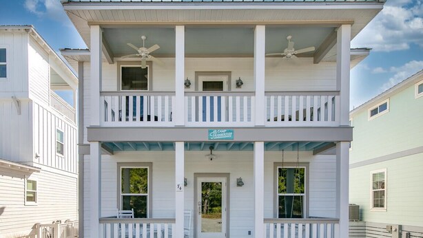 A two-story building with a porch, a sign reading "Camp Bioberrish," and a clear sky. - Stunning 4BR 3BA. Pool. Gym. Pets Welcome. 0.7 mi to beach access (Santa Rosa Beach)