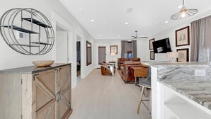A modern kitchen with a marble countertop, a wooden cabinet, and a ceiling fan. - Stunning 4BR 3BA. Pool. Gym. Pets Welcome. 0.7 mi to beach access (Santa Rosa Beach)