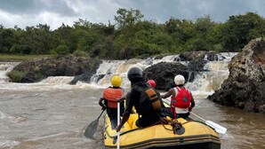 A group of people in a yellow raft navigating a river with a waterfall in the background. - Jangwani Camp Sagana (Murang'a)