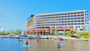 A hotel with multiple floors, a marina with boats, and a tropical setting. - Formosa Yacht Resort (Tainan)