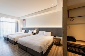 Una habitación de hotel moderna con dos camas, una mesita redonda y un banco empotrado.