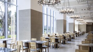 A spacious dining area with high ceilings, large windows, and modern chandeliers. Tables are arranged in rows with wicker chairs. - Formosa Yacht Resort (Tainan)