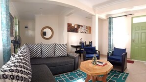 A living room with a sofa, two armchairs, a coffee table, and a mirror on the wall. - LUXE & SPACIOUS ONE BEDROOM UNIT (Kisumu)