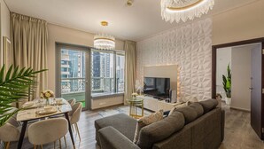 En moderne stue med spiseplads, sofa, fjernsyn og en balkon med udsigt over byen.