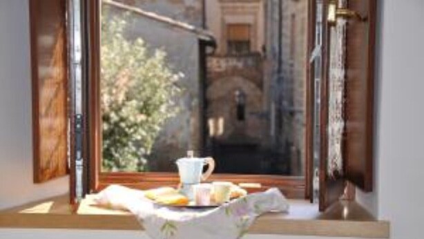 Una ventana con una mesa lista para el desayuno, que incluye una taza y pasteles.