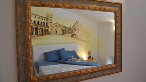 Un dormitorio con cama, almohadas y una mesita de noche.