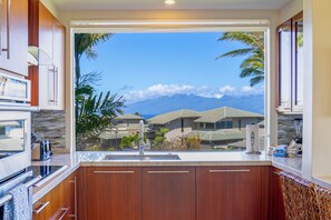 A kitchen with a view of houses and mountains. - SEE our NEW PHOTOS, One of Our BEST, (12B-2) ~ Platinum Maui Vacations (Lahaina)