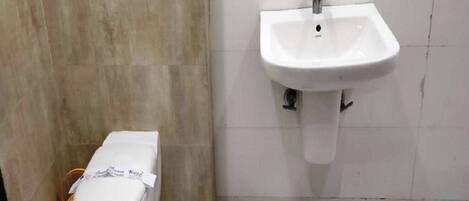 A bathroom with a toilet, sink, and tiled walls.