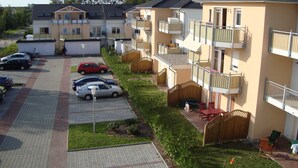 A residential building with multiple balconies, a parking area, and a small garden. - Vacation apartment Strandwiese 3 (Graal-Müritz)
