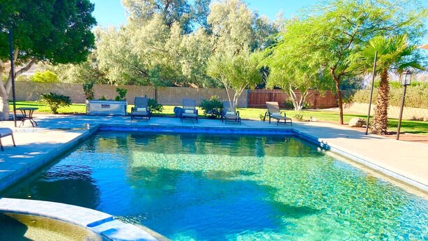 A rectangular swimming pool with clear blue water, surrounded by a paved deck. - Specials! Heated pool+spa|Game room|Sports courts (Thousand Palms)