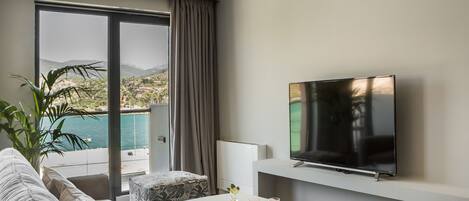 A modern living room with a sofa, a coffee table, and a flat-screen TV.