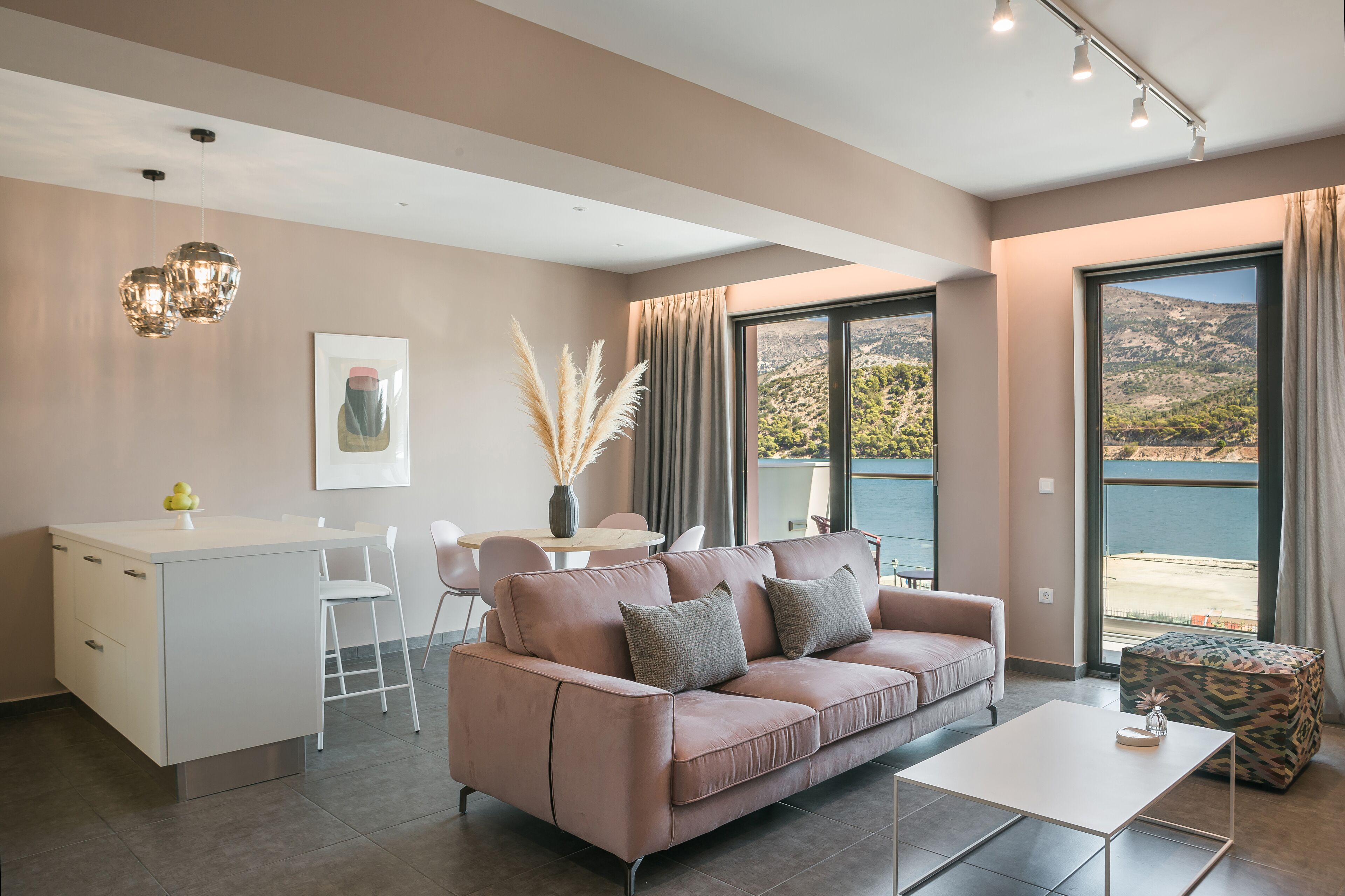 A modern living room with a sofa, a coffee table, and a dining area with chairs.