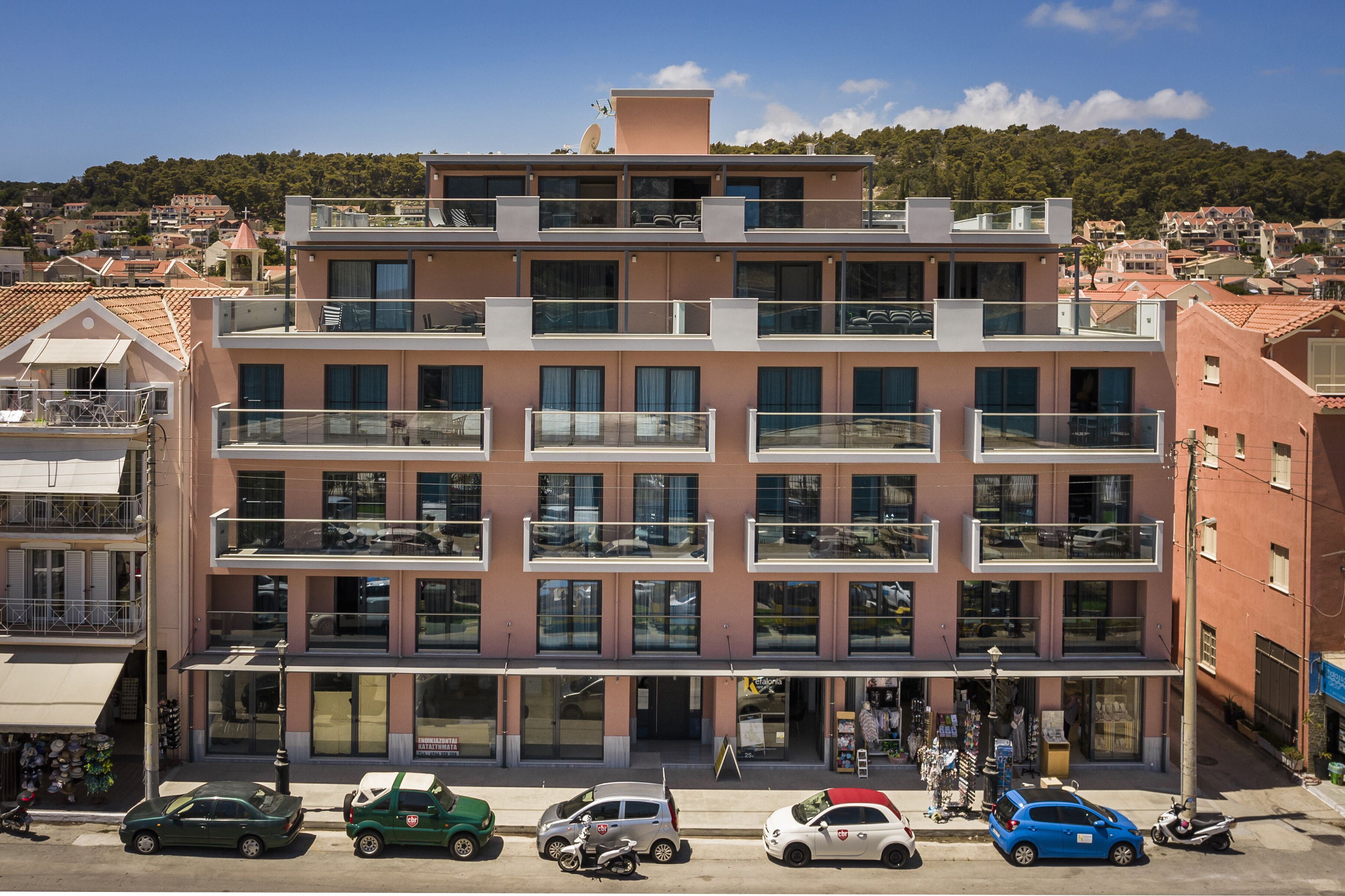 A multi-story building with balconies, a ground-level entrance, and a visible storefront.