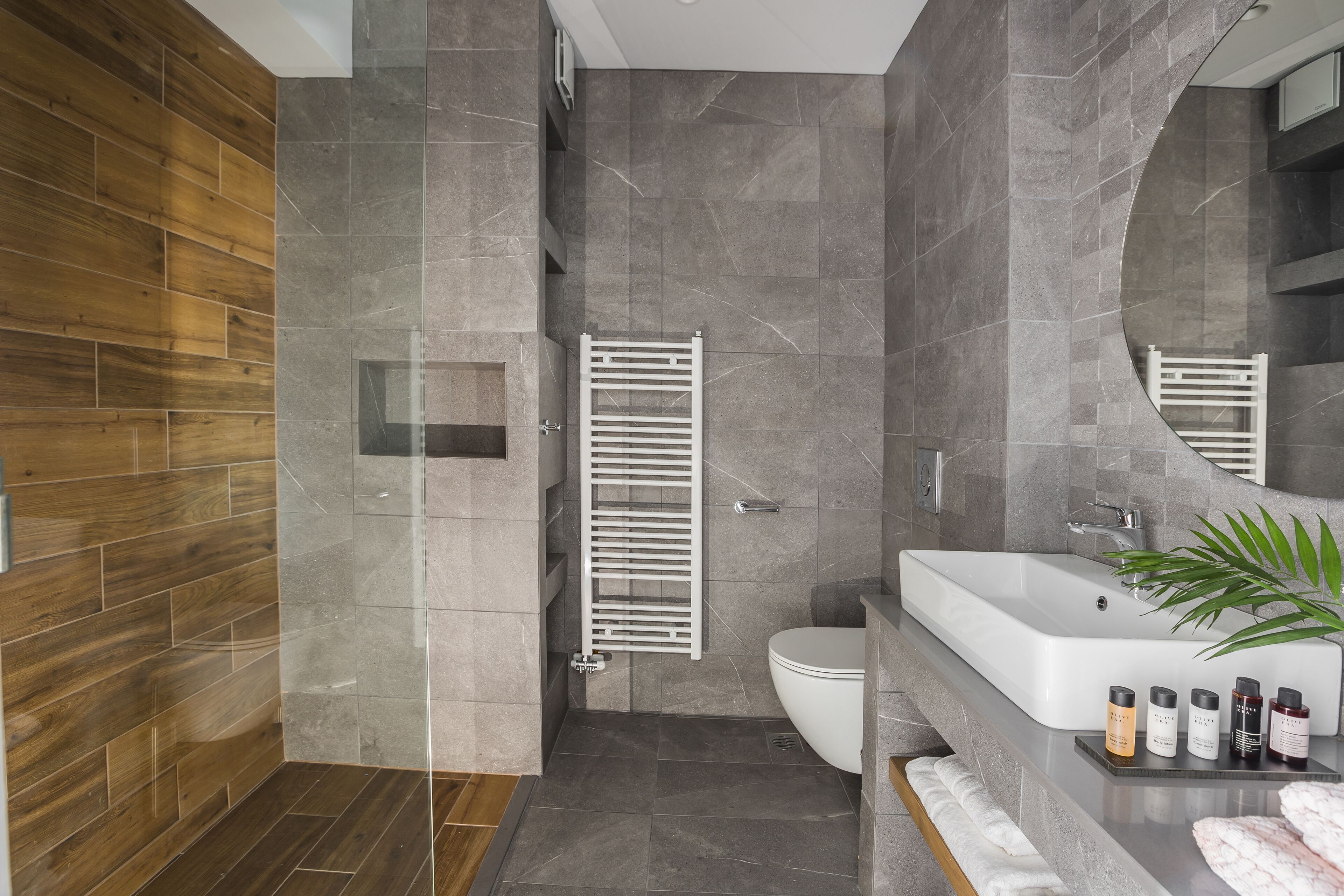 A modern bathroom with a shower, toilet, and sink.