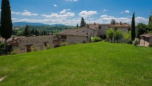 A rural landscape with stone buildings, a grassy field, and a clear blue sky. - Agriturismo Il Forno with Mountain View, Shared Pool and Wi-Fi (Grassina)