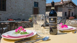 A table set with plates, cutlery, a bottle of Chianti wine, and a glass of water. - Agriturismo Il Forno with Mountain View, Shared Pool and Wi-Fi (Grassina)