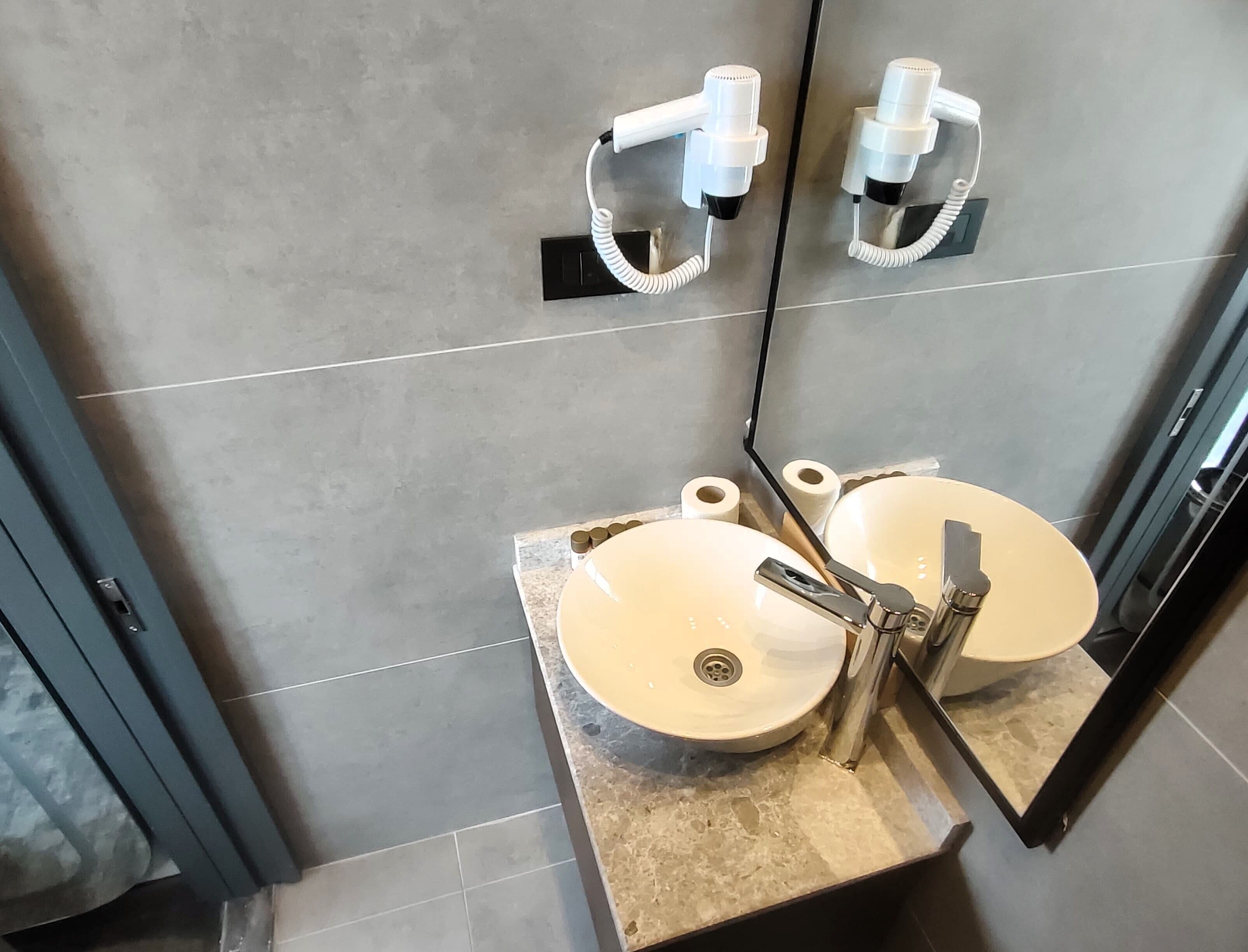 A bathroom with two sinks, a mirror, and a towel rack.