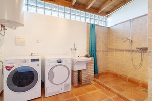 A laundry area with two washing machines, a sink, and a shower. - Villa Las Dalias Almunecar and Nerja (Almunecar)