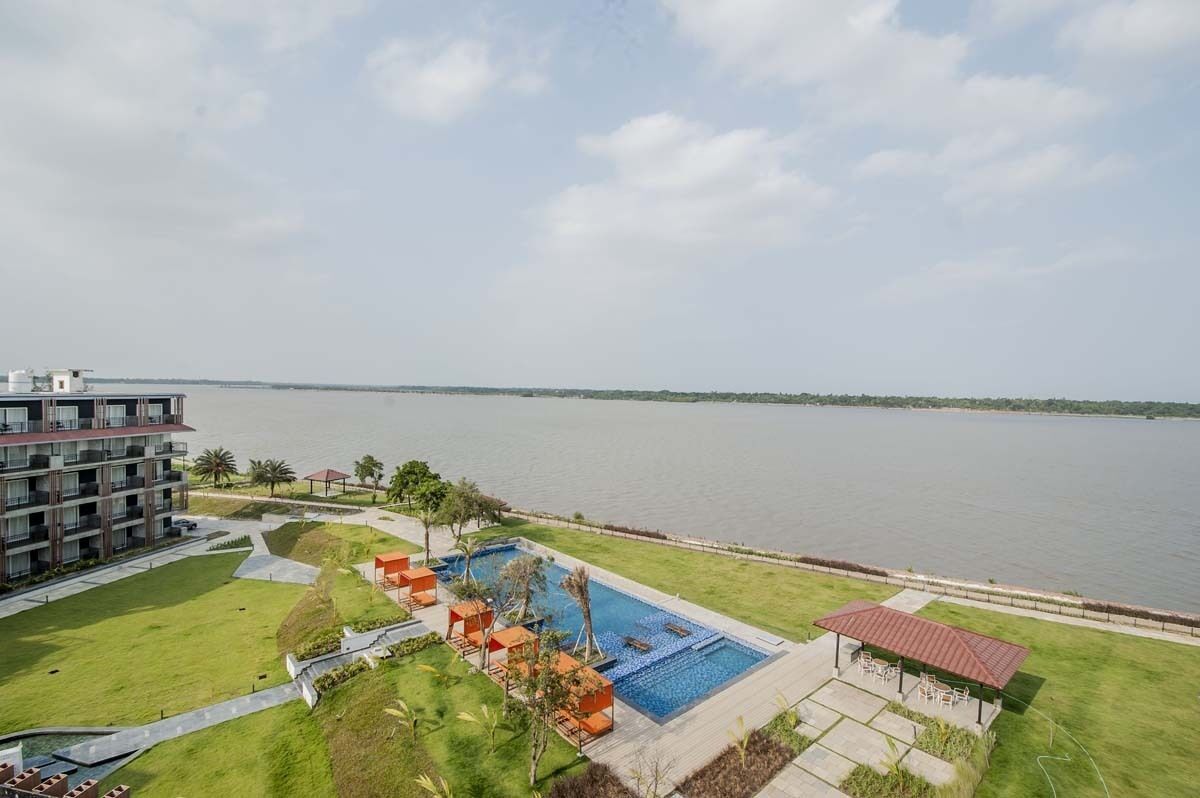 A resort with a swimming pool, a covered seating area, and a view of the water.