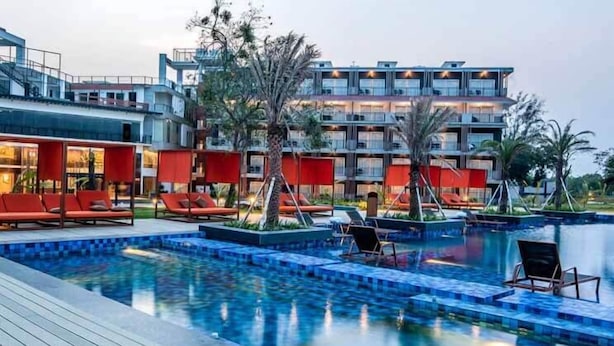 Ein Hotel mit Poolbereich, einschließlich Liegestühlen und einem Wasserspiel.