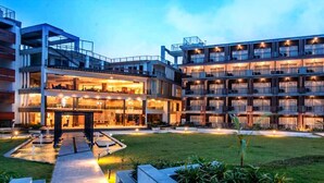 Ein mehrstöckiges Hotel mit Innenhof, Balkonen und einer gut beleuchteten Fassade.