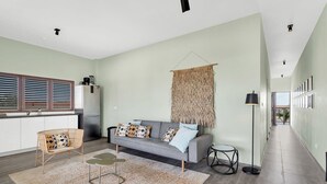 Una sala moderna con un sofá, una mesa de centro y una lámpara de pie.
