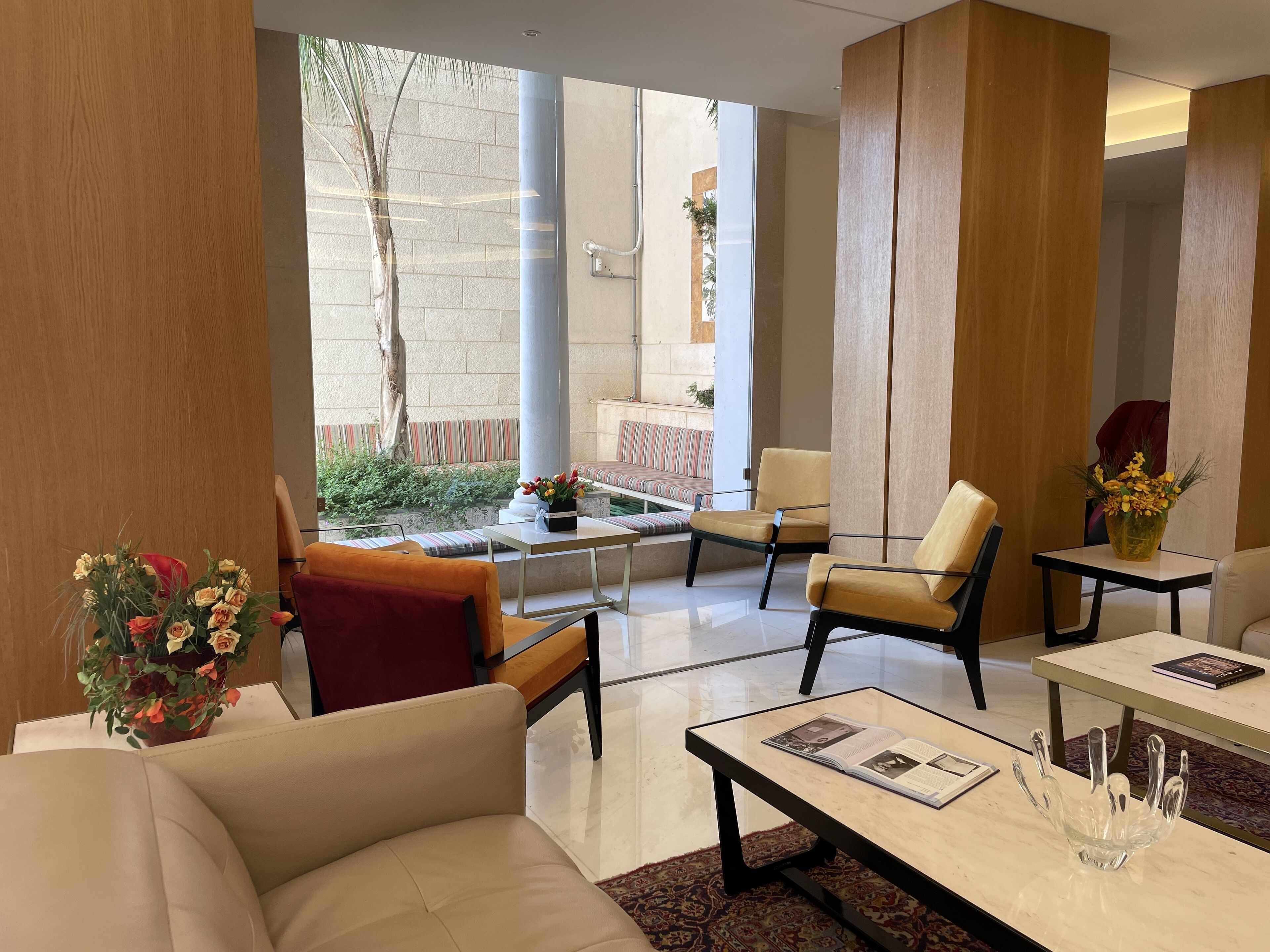 Un hall moderno con un sofá, sillas, una mesa de centro y vistas al exterior.