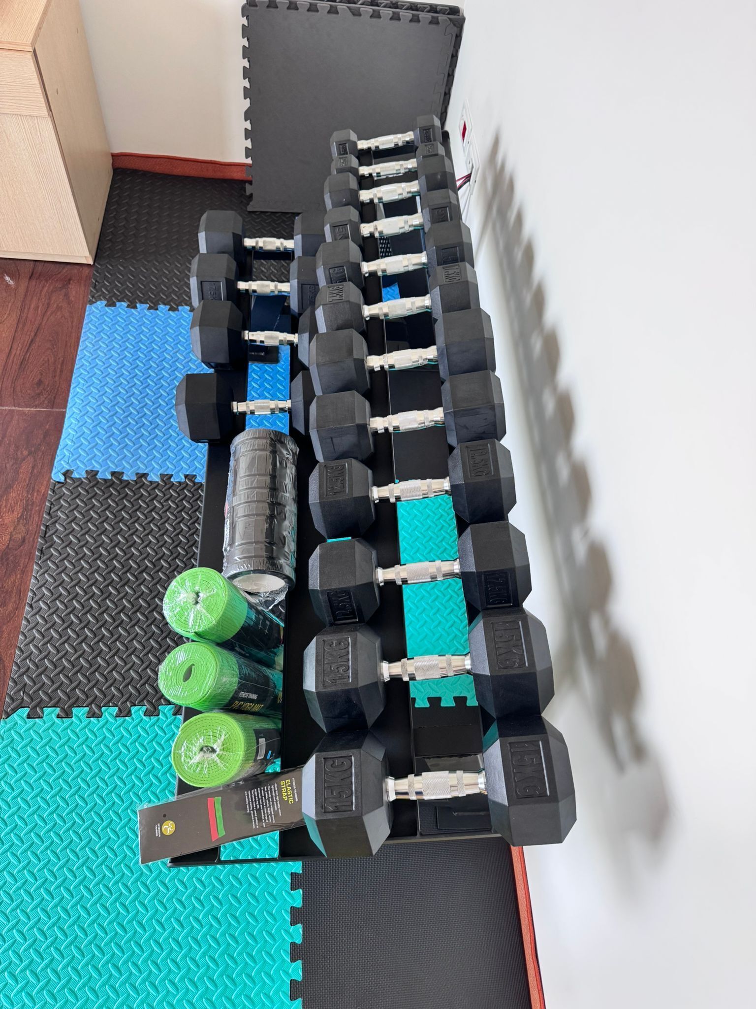 A home gym with various exercise equipment, including dumbbells, resistance bands, and a yoga mat.