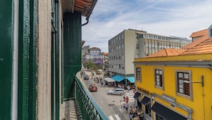 A street view with buildings, a café, and pedestrians. - Invictus Hostel (Porto)