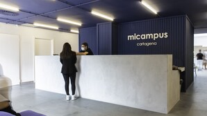 Een receptiegedeelte met een modern design, met een receptiebalie met de tekst 'micampus cartagena'.
