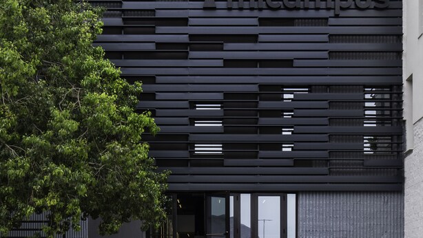 Een modern gebouw met een trap naar de ingang.