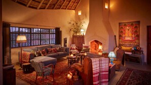Una sala de estar acogedora con chimenea, asientos cómodos y un ventanal grande.