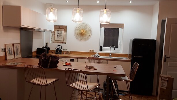 A compact kitchen with a central island, pendant lights, a refrigerator, and a dining area with chairs. - O Tour's Angels "Rabelais" (37000 TOURS)