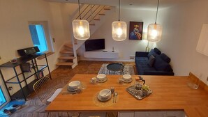 A modern kitchen with a wooden island, dining table set with plates and glasses, and pendant lights. - O Tour's Angels "Rabelais" (37000 TOURS)