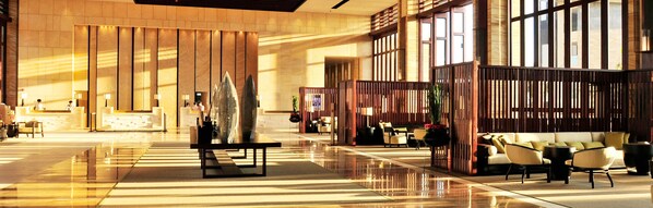 A spacious lobby with a reception desk, seating areas, and decorative elements.