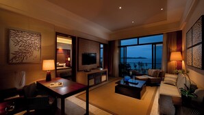 Un salon spacieux doté d’un grand téléviseur à écran plat, de sièges confortables et d’un balcon offrant une vue sur la mer.